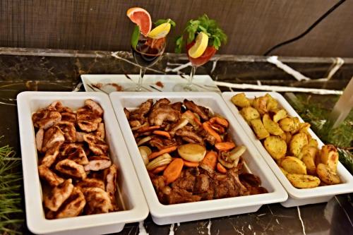 four dishes of food on a table with two glasses of wine at Katalina SPA Resort in Tsigov Chark