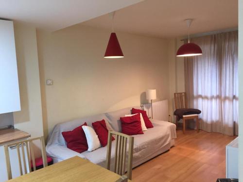 a living room with a white couch with red pillows at TU APARTAMENTO EN EL VALLE DE TENA en ESCARRILLA in Escarrilla