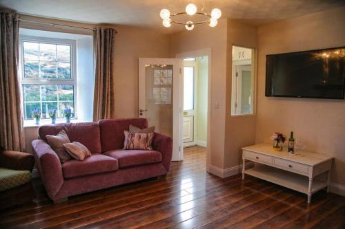 a living room with a couch and a table at Ceim house, Restful rural home Gap of dunloe, Killarney in Derrylea