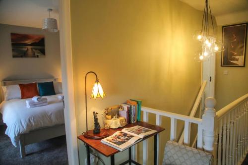 a bedroom with a bed and a table with books at Ceim house, Restful rural home Gap of dunloe, Killarney in Derrylea