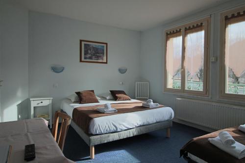 um quarto de hotel com duas camas num quarto em Hotel Au Val Doré em La Bourboule