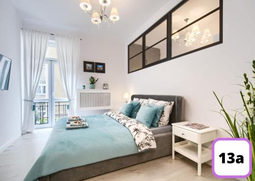 华沙Sienna 41 Boutique Warsaw Apartments的一间卧室配有一张床和一个吊灯