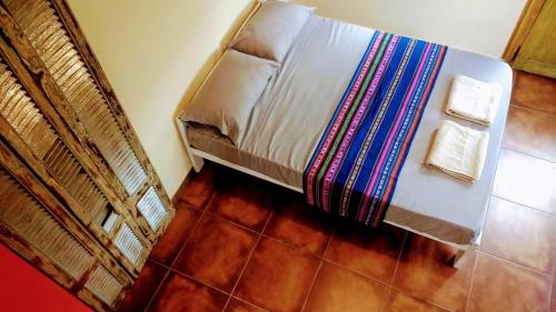 a bedroom with a bed with a colorful blanket at apartamento VINTAGE IVA in Merlo