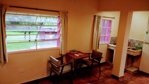 een kamer met een tafel, een raam en een wastafel bij apartamento VINTAGE IVA in Merlo