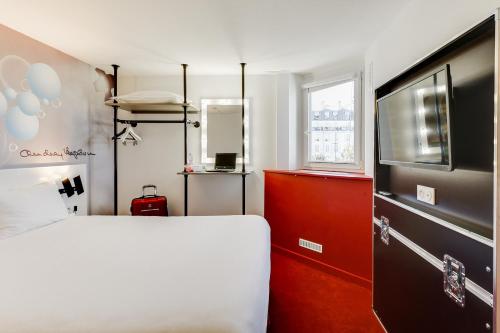 a bedroom with a white bed and a television at Ibis Styles Paris Saint Denis La Plaine in Saint-Denis