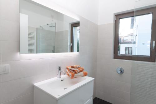 uma casa de banho branca com um lavatório e um espelho em Bella Lago em Acquaseria