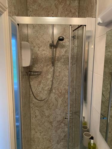 a shower with a glass door in a bathroom at Deverill End in Warminster