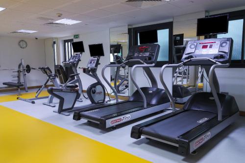 a gym with several treadmills and cardio machines at Raouche Arjaan by Rotana in Beirut