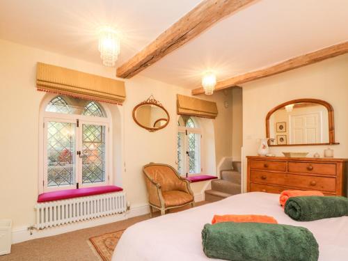 - une chambre avec un lit, une commode et des fenêtres dans l'établissement Chapel Cottage, à Stroud