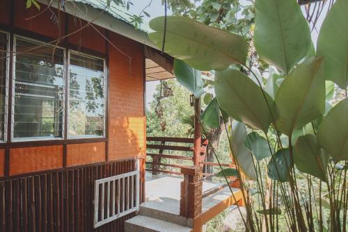 a house with a staircase leading to the front porch at Baansuan Chomchun in Amphoe Mae Taeng