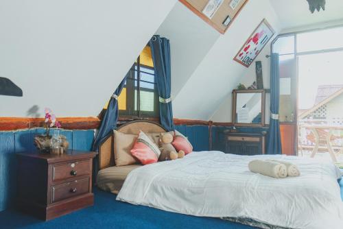 a bedroom with a bed and a dresser and a staircase at Baansuan Chomchun in Amphoe Mae Taeng