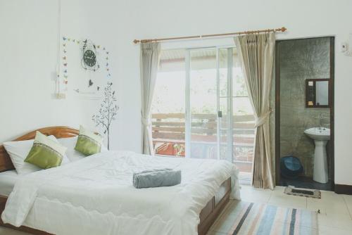 a bedroom with a large bed and a window at Baansuan Chomchun in Amphoe Mae Taeng