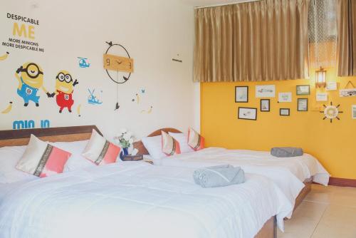 a bedroom with two beds and a wall with stickers at Baansuan Chomchun in Amphoe Mae Taeng
