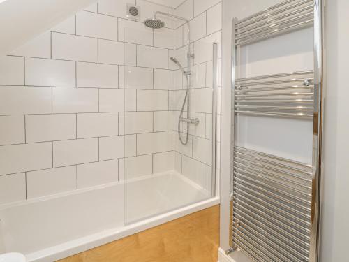 a white bathroom with a shower and a tub at May Cottage in Scarborough