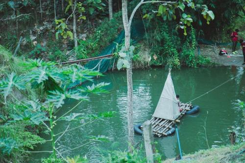 a person in a hammock on a raft in the water at Baansuan Chomchun in Amphoe Mae Taeng