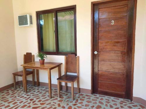 a room with a table and a wooden door at Two Season Tourist Inn in San Vicente