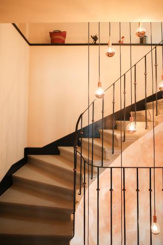 a staircase with black railings and pendant lights at Casa ViniToscani in Perroy