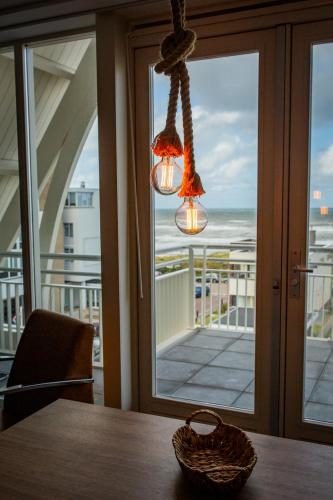 a chandelier hanging over a table with a view of the ocean at Villa Zeezicht in Noordwijk