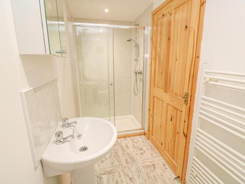 uma casa de banho com um lavatório e um chuveiro em The Stable em Penzance