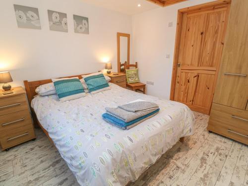 um quarto com uma cama e uma porta de madeira em The Stable em Penzance
