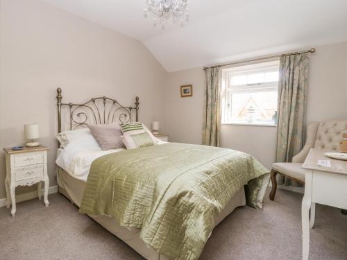 a bedroom with a bed and a window and a chair at 1 Church Barns in Great Driffield