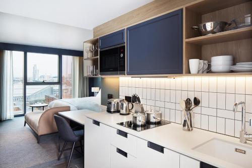 a kitchen with a sink and a counter top at Hyatt House Manchester - Aparthotel in Manchester