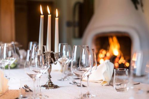 a group of wine glasses on a table with a fireplace at Hotel Dreiflüssehof in Passau