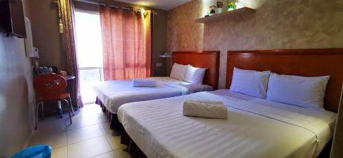 a hotel room with two beds and a window at Boutique Hote123 in Kuala Lumpur