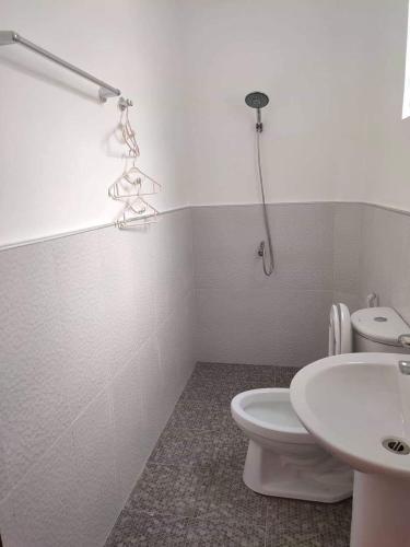 a bathroom with a white toilet and a sink at Two Season Tourist Inn in San Vicente