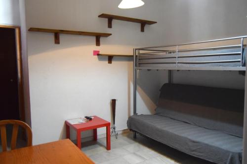 セビリアにあるApartamento Feria 2の二段ベッドとテーブルが備わる小さな客室です。