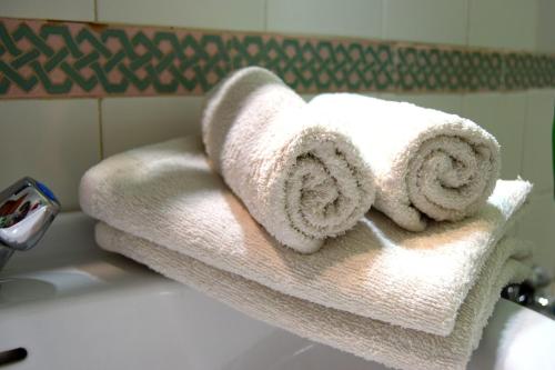 einen Stapel Handtücher auf einem Waschbecken in der Unterkunft Apartamento Feria 2 in Sevilla