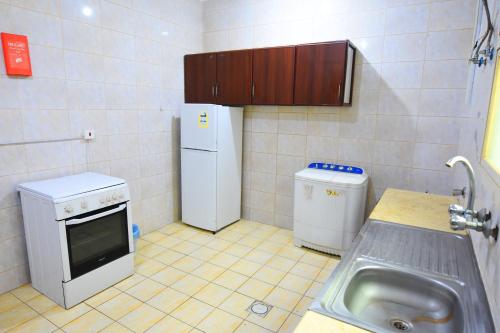 Elle comprend une petite cuisine équipée d'un évier et d'un réfrigérateur. dans l'établissement Al Eairy Apartments - Hail 3, à Haïl