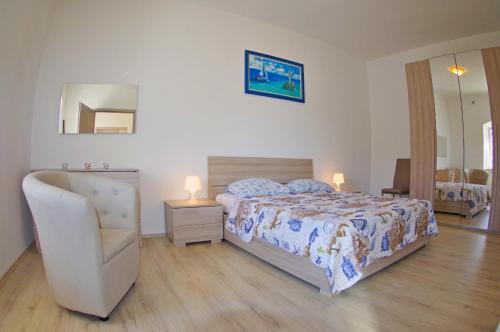 a bedroom with a bed and a chair and a mirror at Holiday apartments in house Sanja in Rakalj