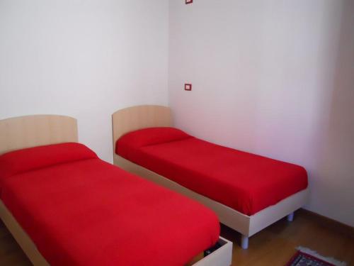 two beds with red covers in a room at Ca della Musica Venezia Santa Croce in Venice