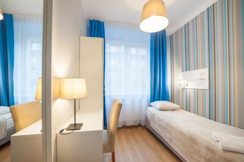 - une chambre avec un lit et un bureau avec une lampe dans l'établissement Premium Hostel, à Cracovie