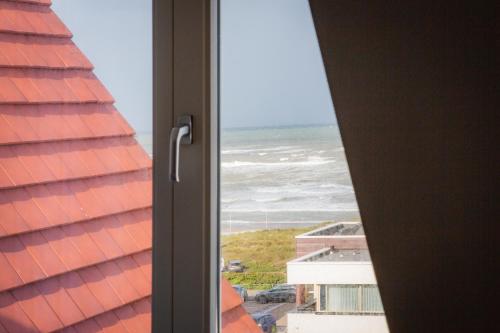 a view of the ocean from a window at Villa Zeezicht in Noordwijk