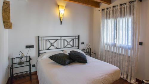 a bedroom with a bed with two pillows on it at Ca la Teresa in Ribera de Montardit