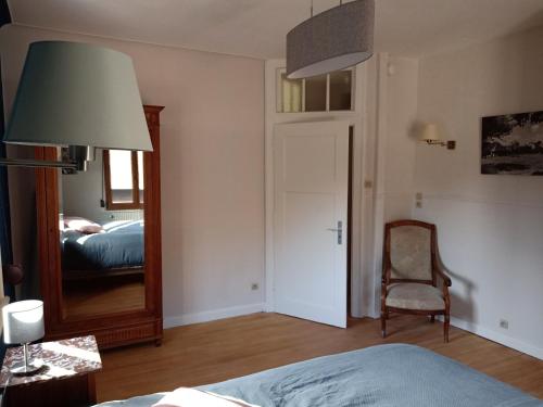 a bedroom with a mirror and a bed and a chair at Chambre double dans Auberge Alsacienne in Scherwiller