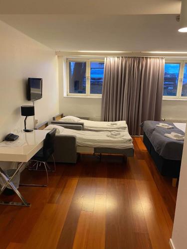 a room with two beds and a desk and a desk at Hotell Alfred Nobel in Karlskoga