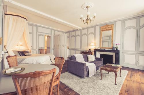 a bedroom with a bed and a couch and a fireplace at La Maison de la Liberté Suite Jeanne Barret in Poitiers