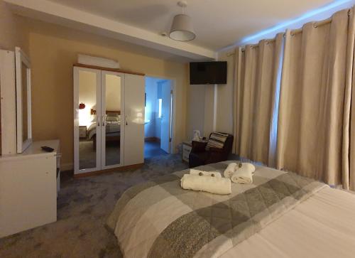 a bedroom with a large bed with towels on it at The Bowers Bar & Restaurant in Ballinrobe