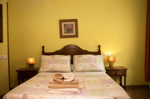 a bed with towels and two donuts on it at Apartamentos la Regoria in Arenas de Cabrales