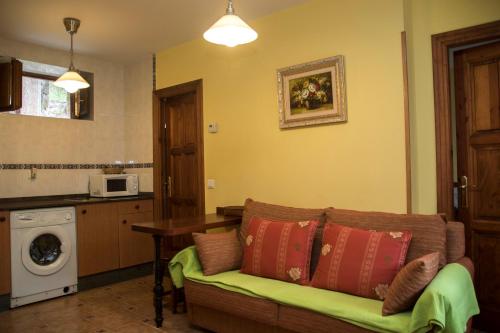 Il comprend un salon avec un canapé et une cuisine. dans l'établissement Apartamentos la Regoria, à Arenas de Cabrales