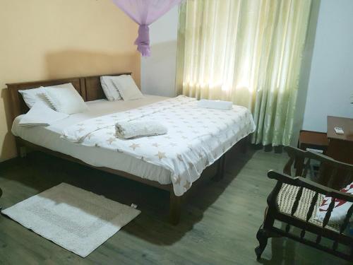a bedroom with a large bed with white sheets at Mount View Inn in Kandy