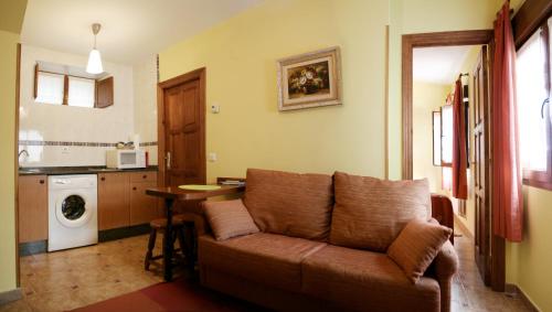 a living room with a couch and a kitchen at Apartamentos la Regoria in Arenas de Cabrales