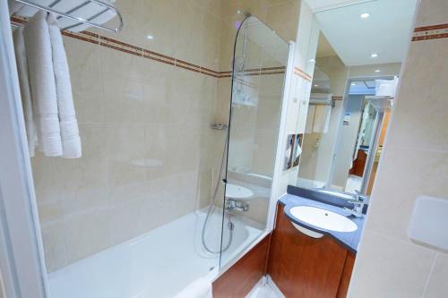 La salle de bains est pourvue d'une douche et d'un lavabo. dans l'établissement Kyriad Paris Nord Porte de St Ouen, à Saint-Ouen