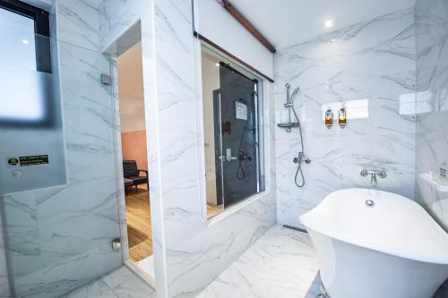 a white bathroom with a shower and a sink at 澎湖 就這兒旅居 in Magong