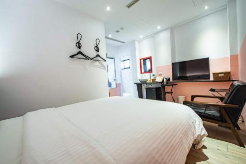 a bedroom with a white bed with scissors on the wall at 澎湖 就這兒旅居 in Magong