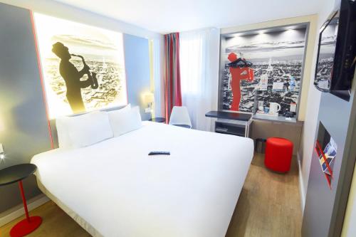 サン・トゥアンにあるキリヤード パリ ノール ポルト ドゥ サントゥアンの白いベッドと女性の写真が備わるベッドルーム1室