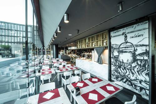 a restaurant with red and white tables and chairs at Best Western Plus Net Tower Hotel Padova in Padova